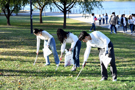 롯데홈쇼핑 임직원들이 플로깅(걸으면서 쓰레기를 줍는 활동)에 참여하고 있다. 롯데홈쇼핑 제공